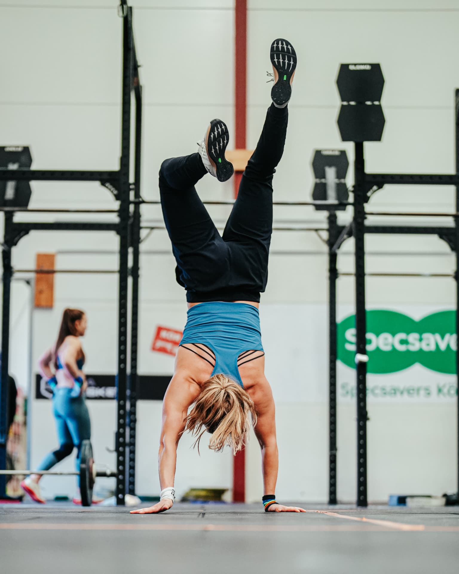 Athlete holding a handstand walk position in the gym