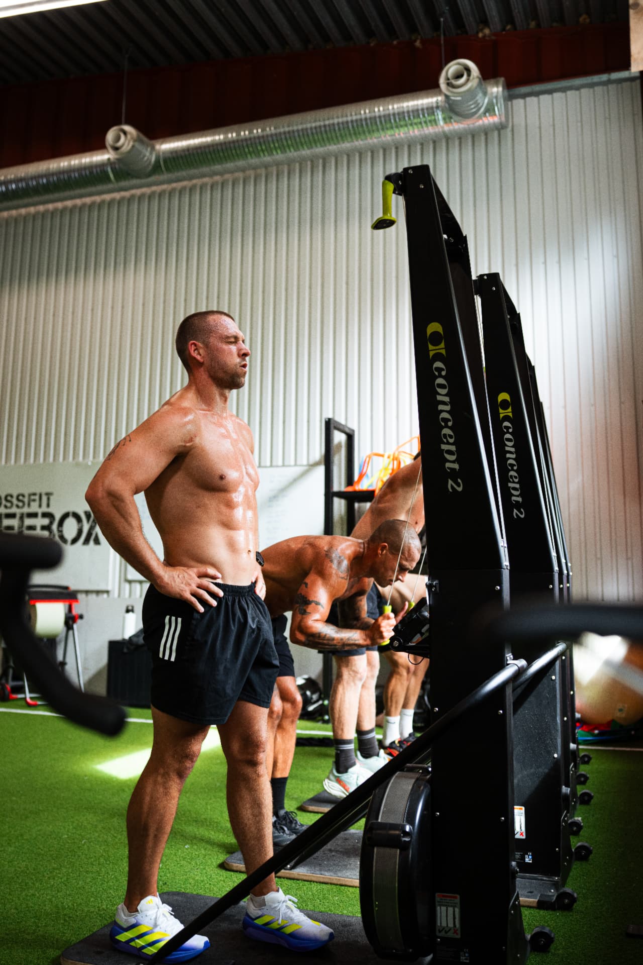 Athletes working on Concept2 machines in the gym