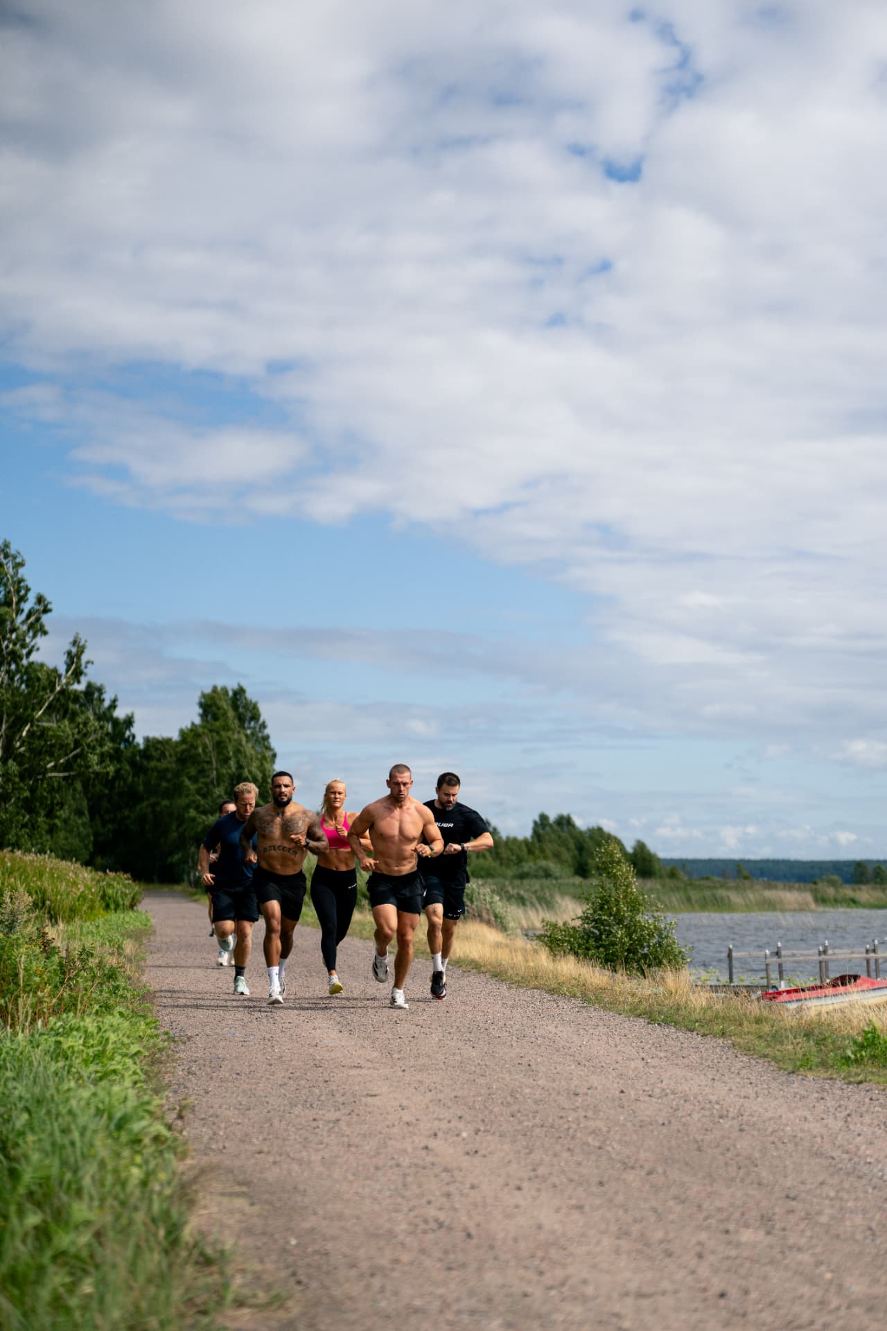 Group of athletes running together on a gravel path