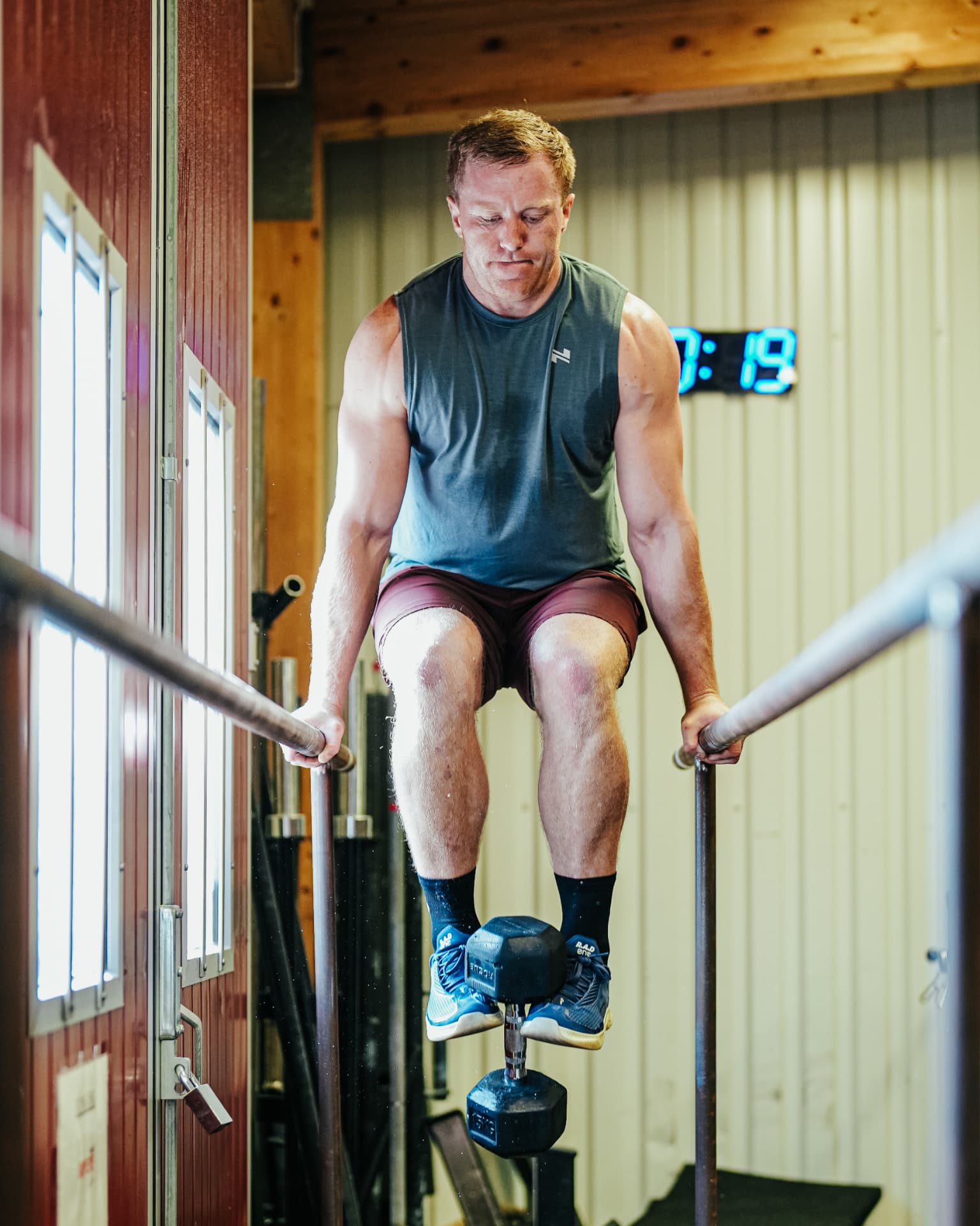 Athlete holding an L-sit position on parallel bars in the gym