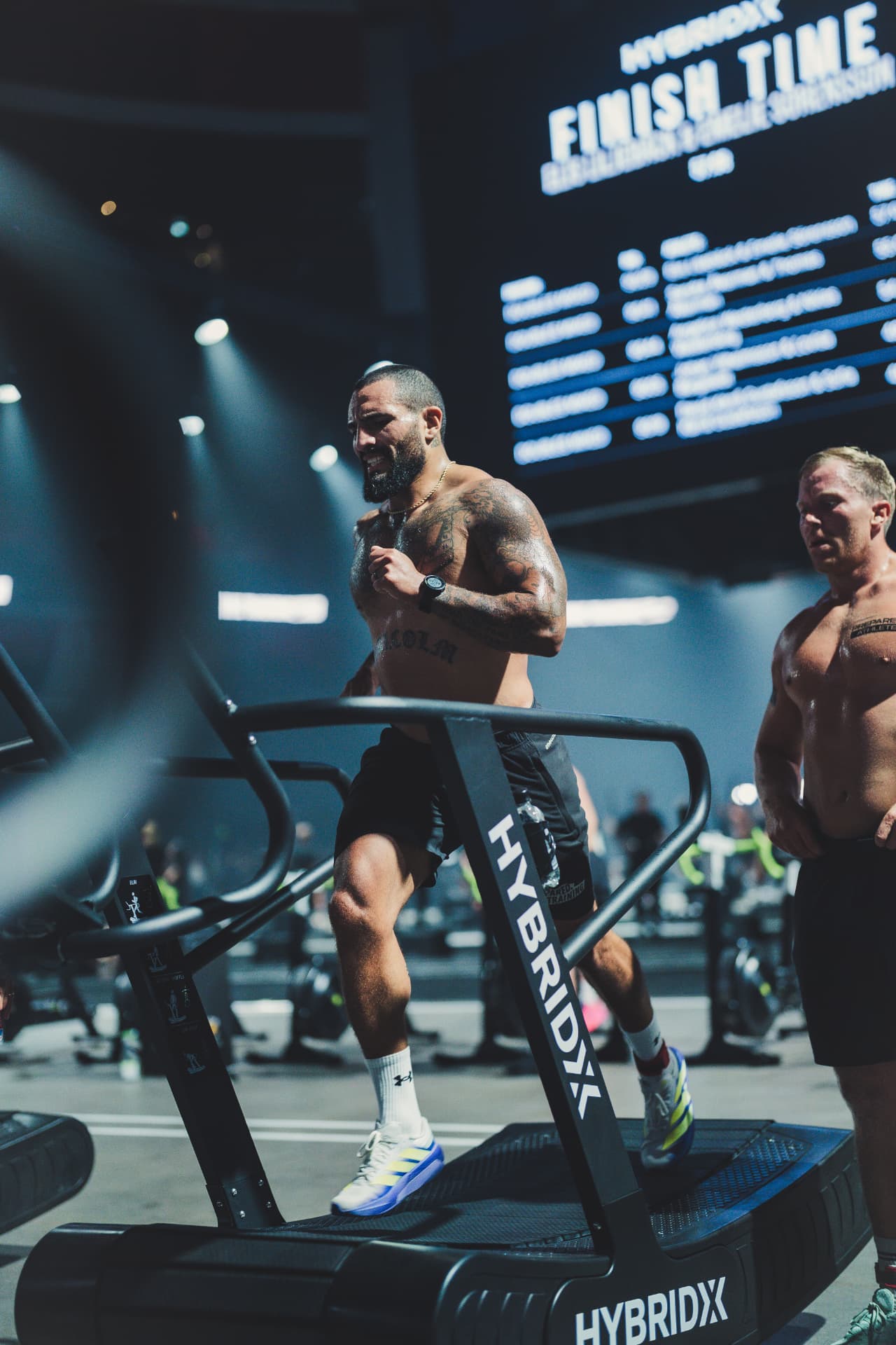 Athlete competing on a HYBRIDX treadmill under the finish-time screen