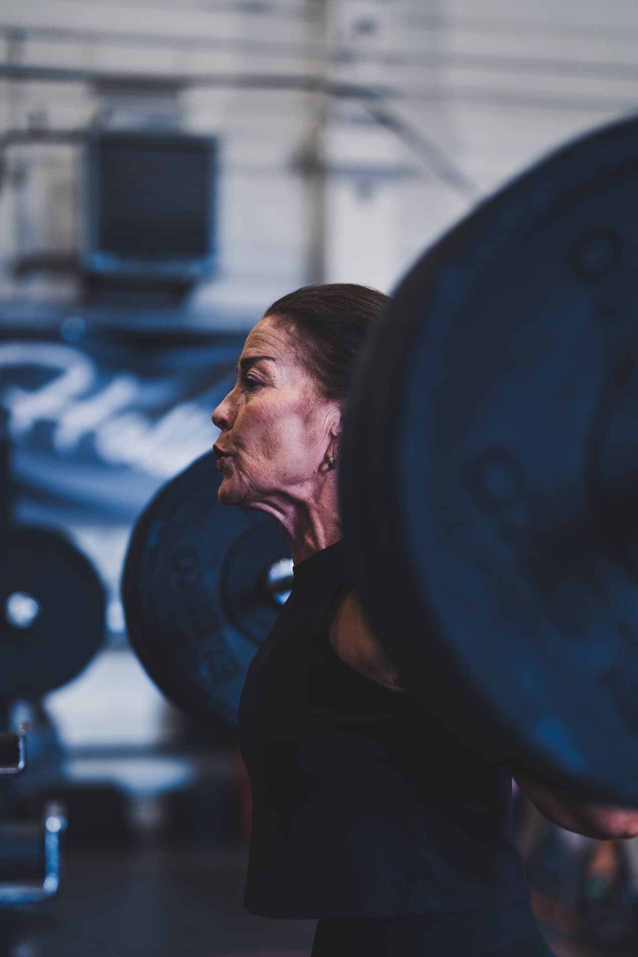 Athlete holding a loaded barbell on the back rack in profile