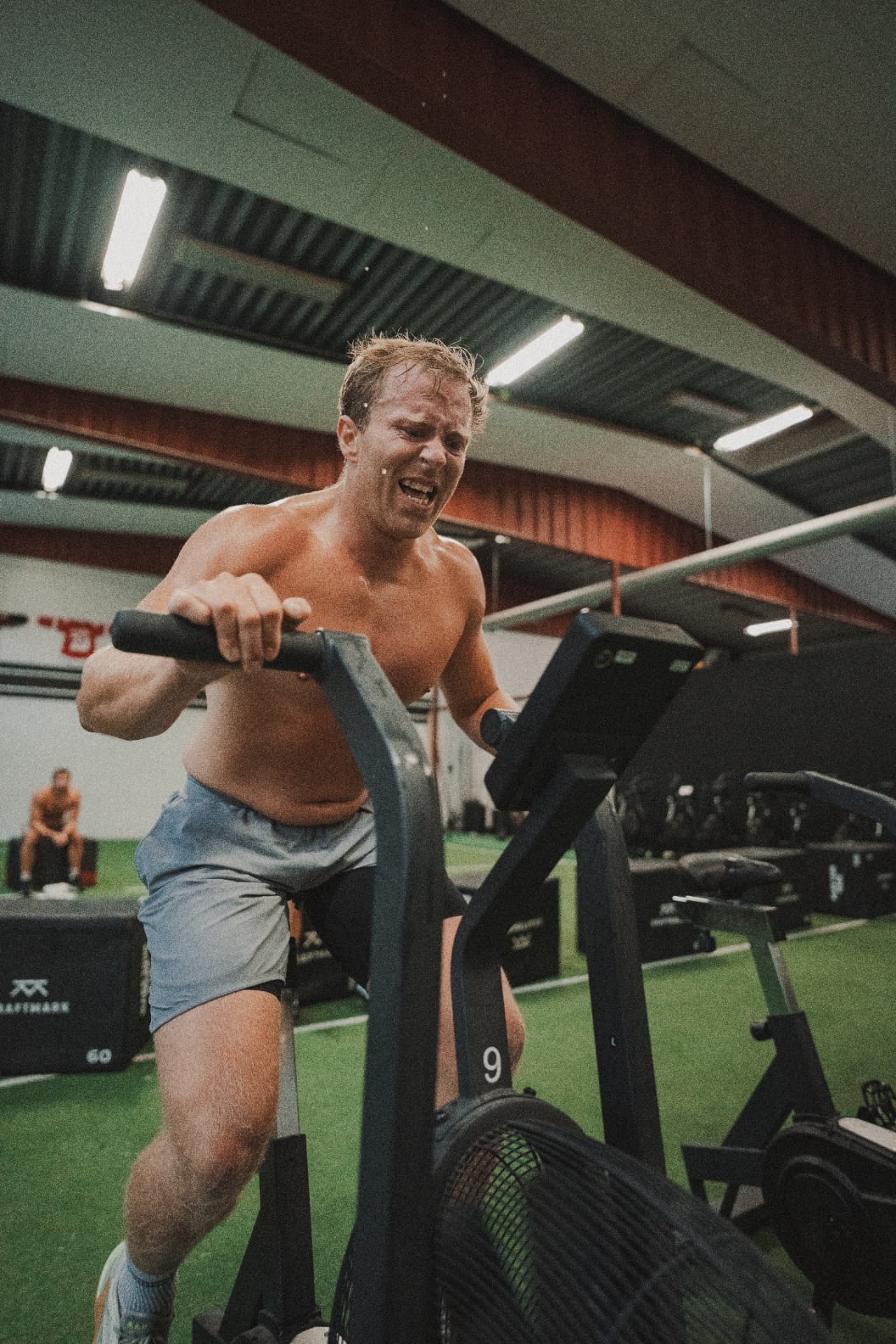 Athlete working through a hard effort on the air bike